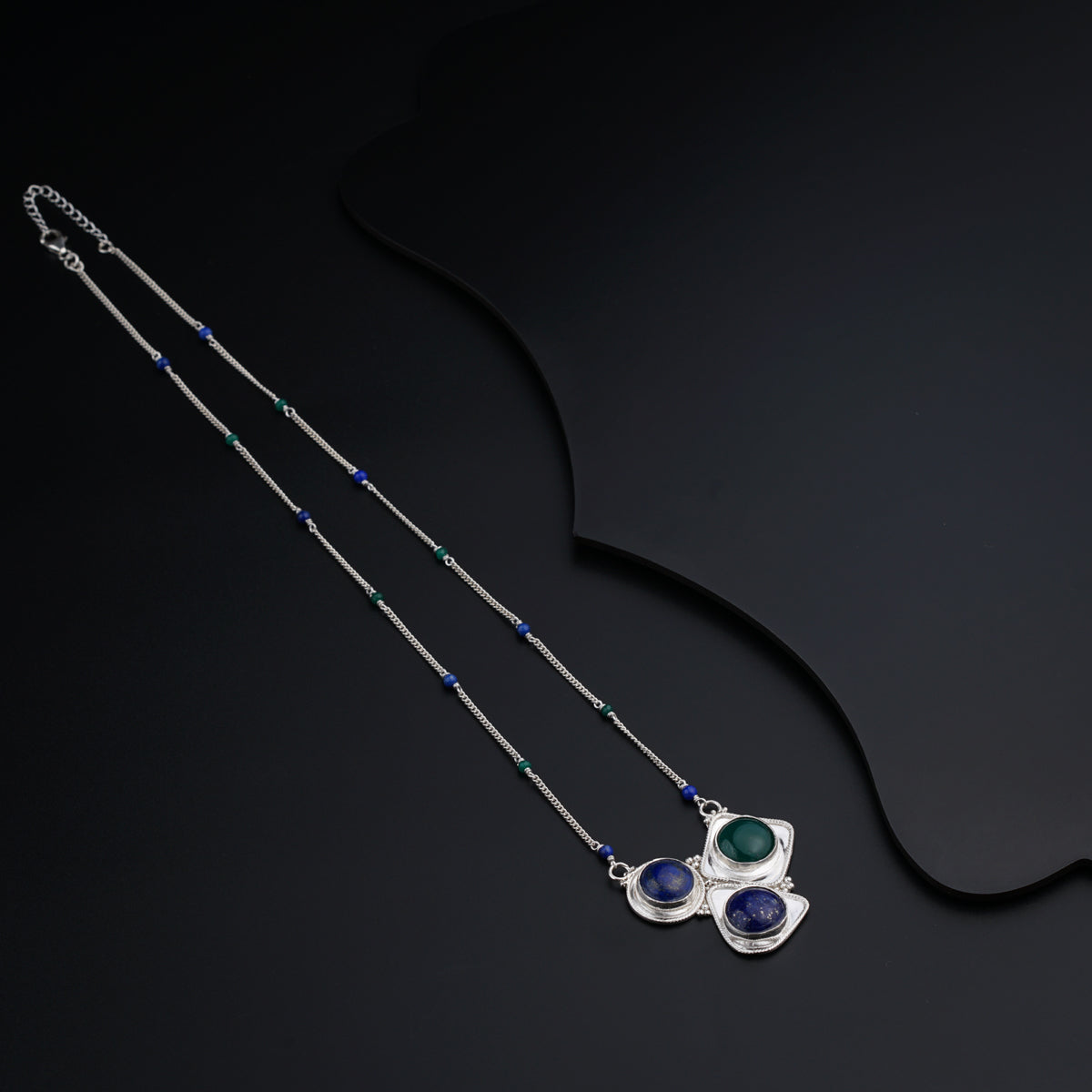 a pair of necklaces on a black background
