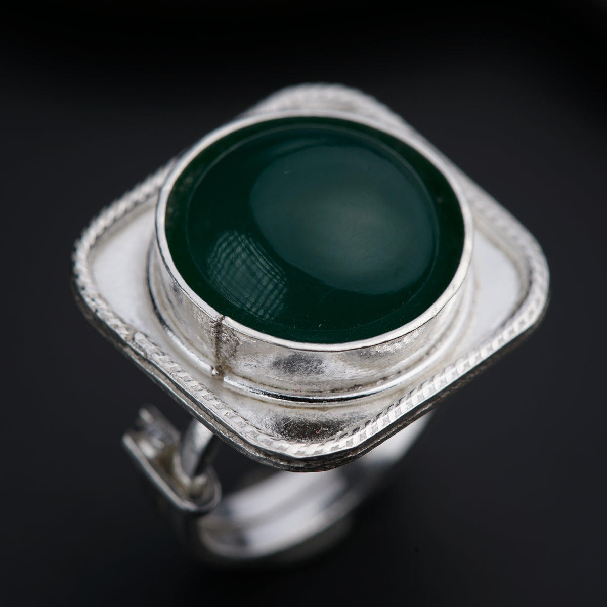 a close up of a green ring on a black surface
