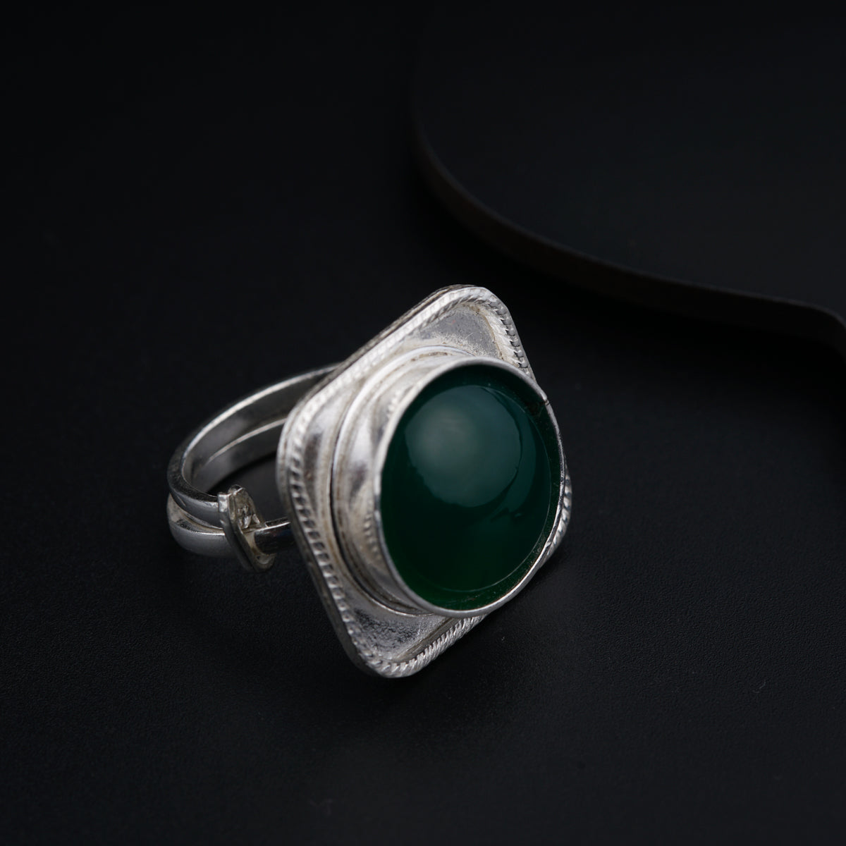a green ring sitting on top of a black surface