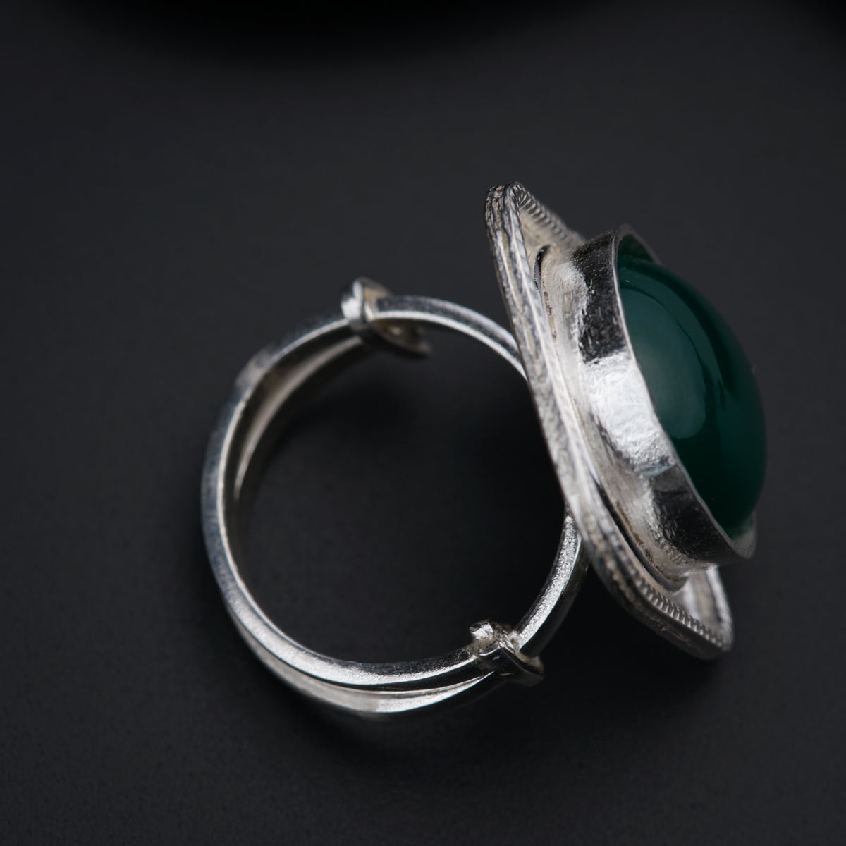 a close up of a ring with a green stone