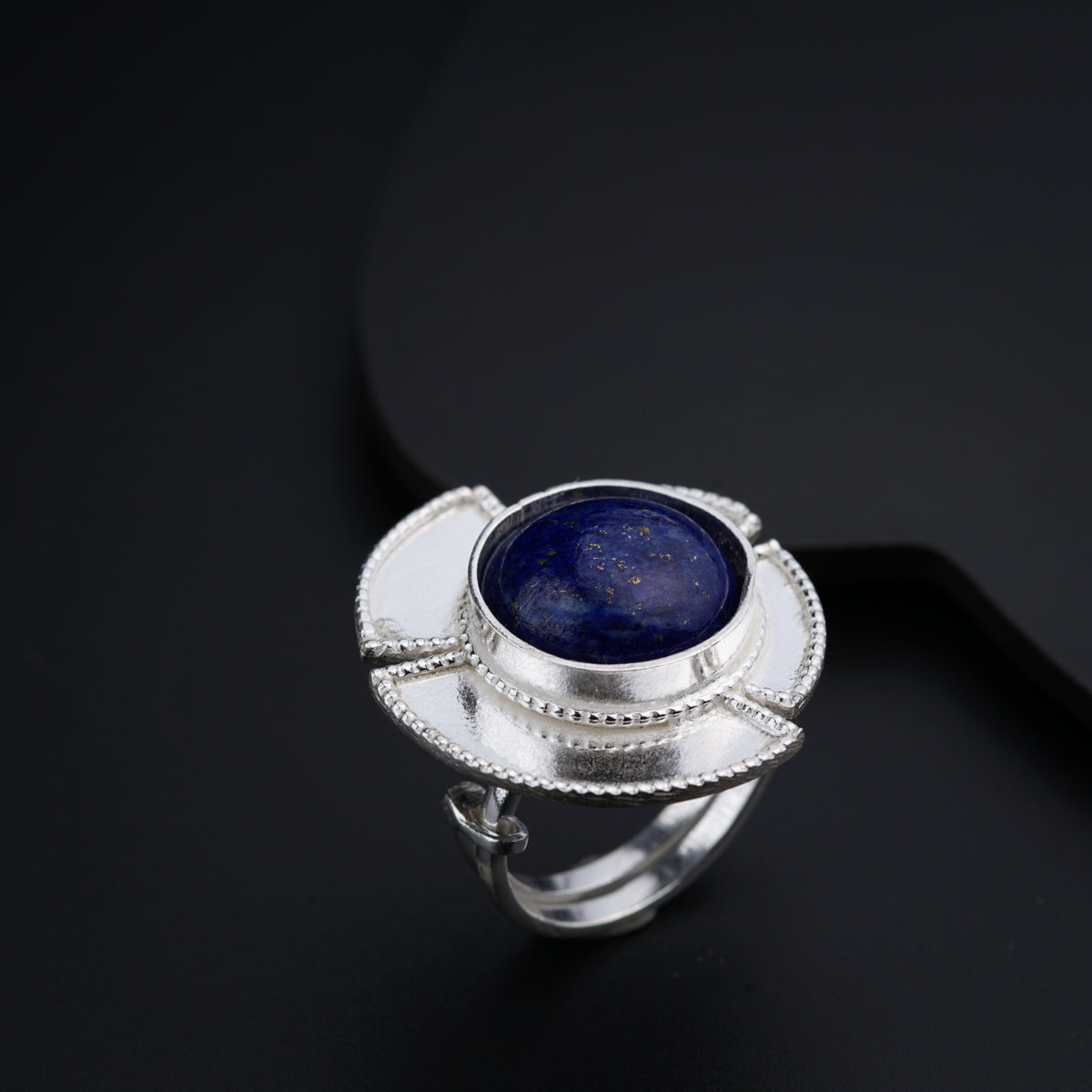 a silver ring with a blue stone in it