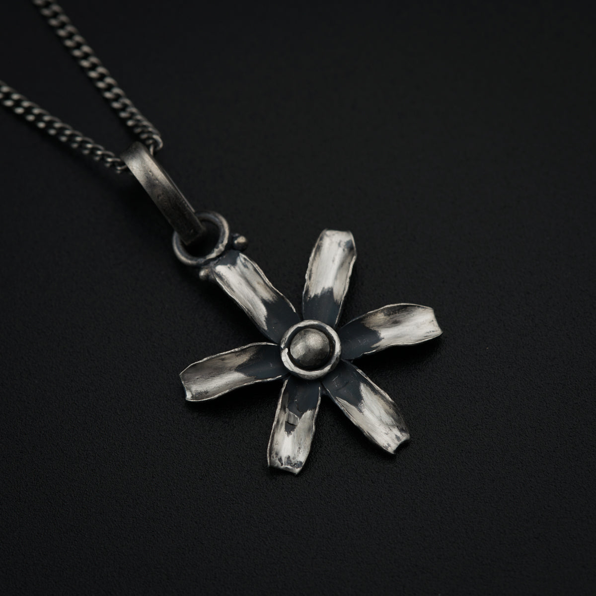 a silver necklace with a flower design on it