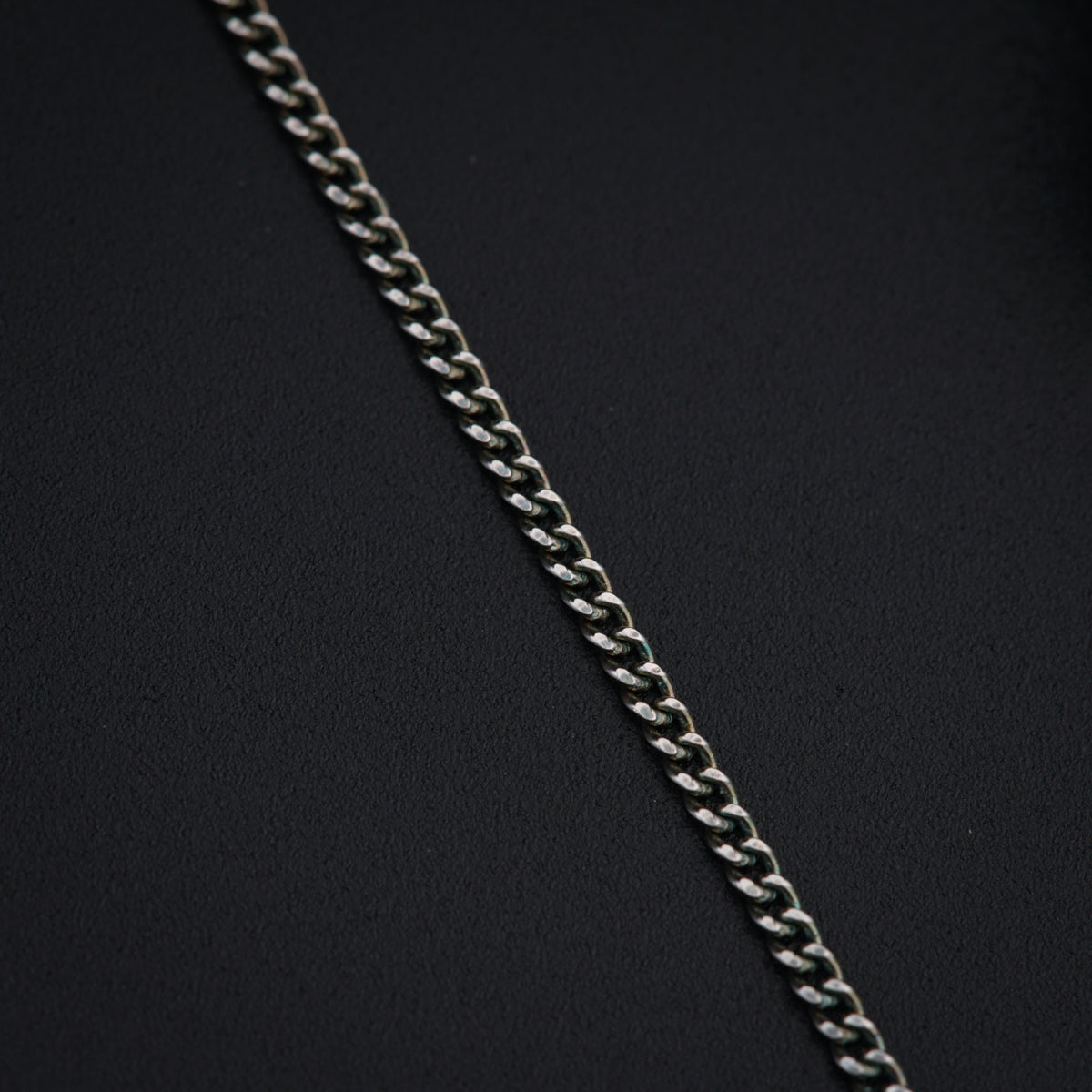 a close up of a chain on a black surface