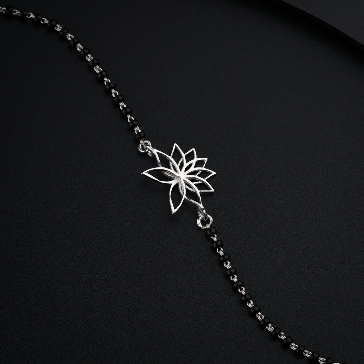 a necklace with a flower on a chain