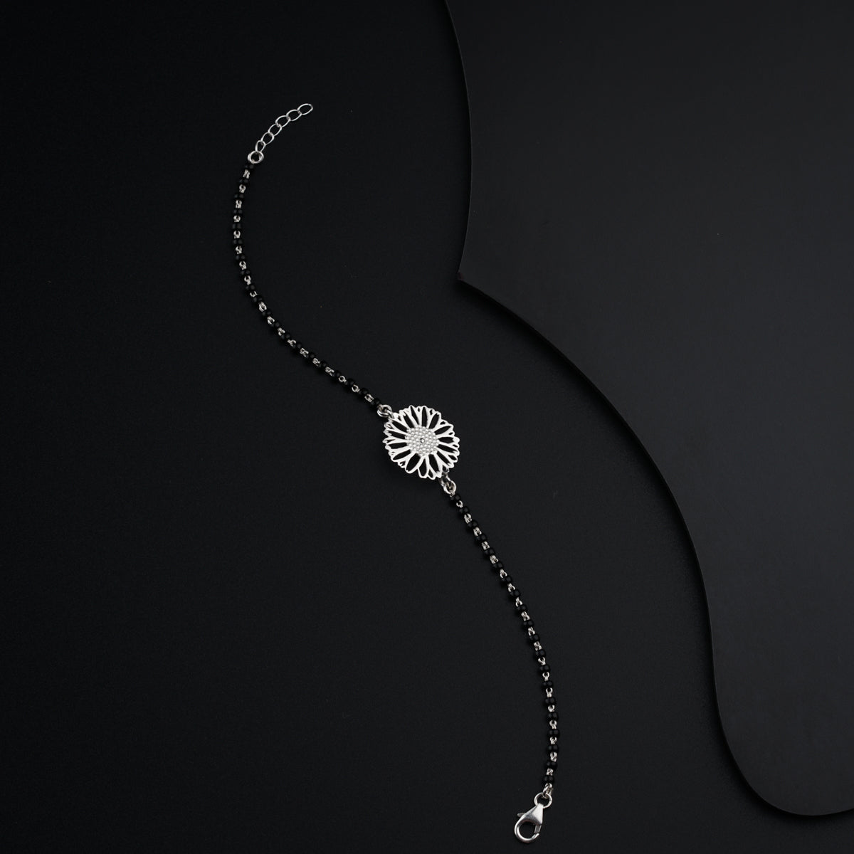 a black and white photo of a necklace on a black background