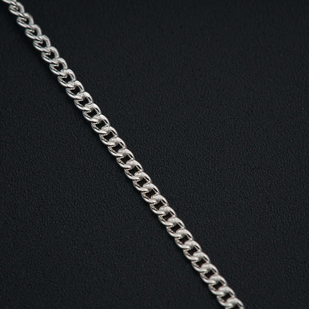 a close up of a chain on a black surface