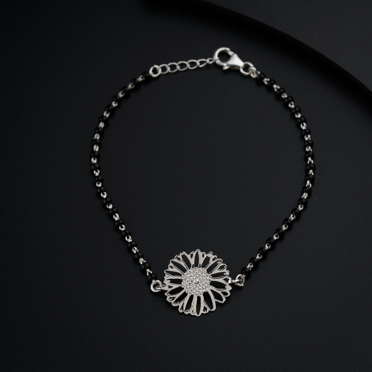 a black beaded bracelet with a flower on it