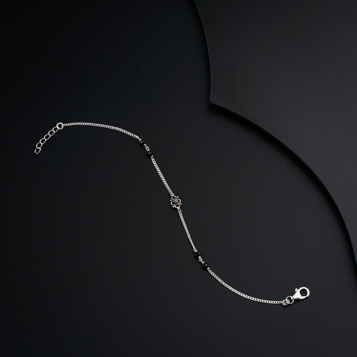 a silver chain with a clasp on a black background