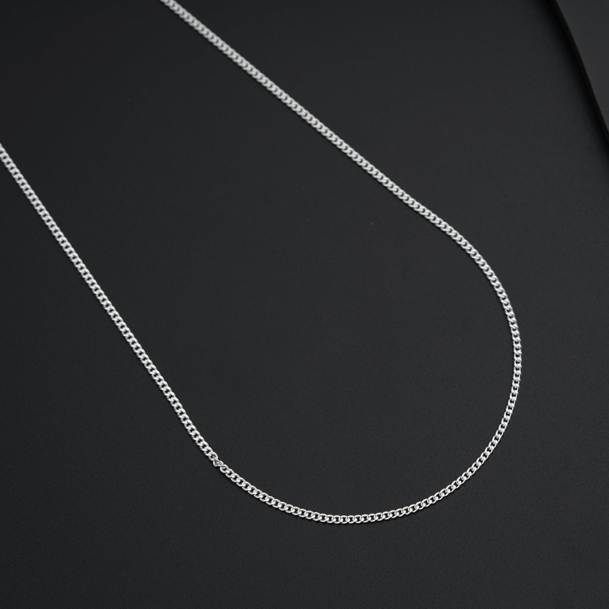 a silver chain on a black surface