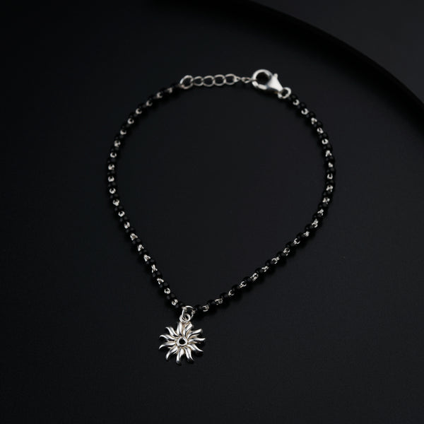 a black beaded bracelet with a silver star charm