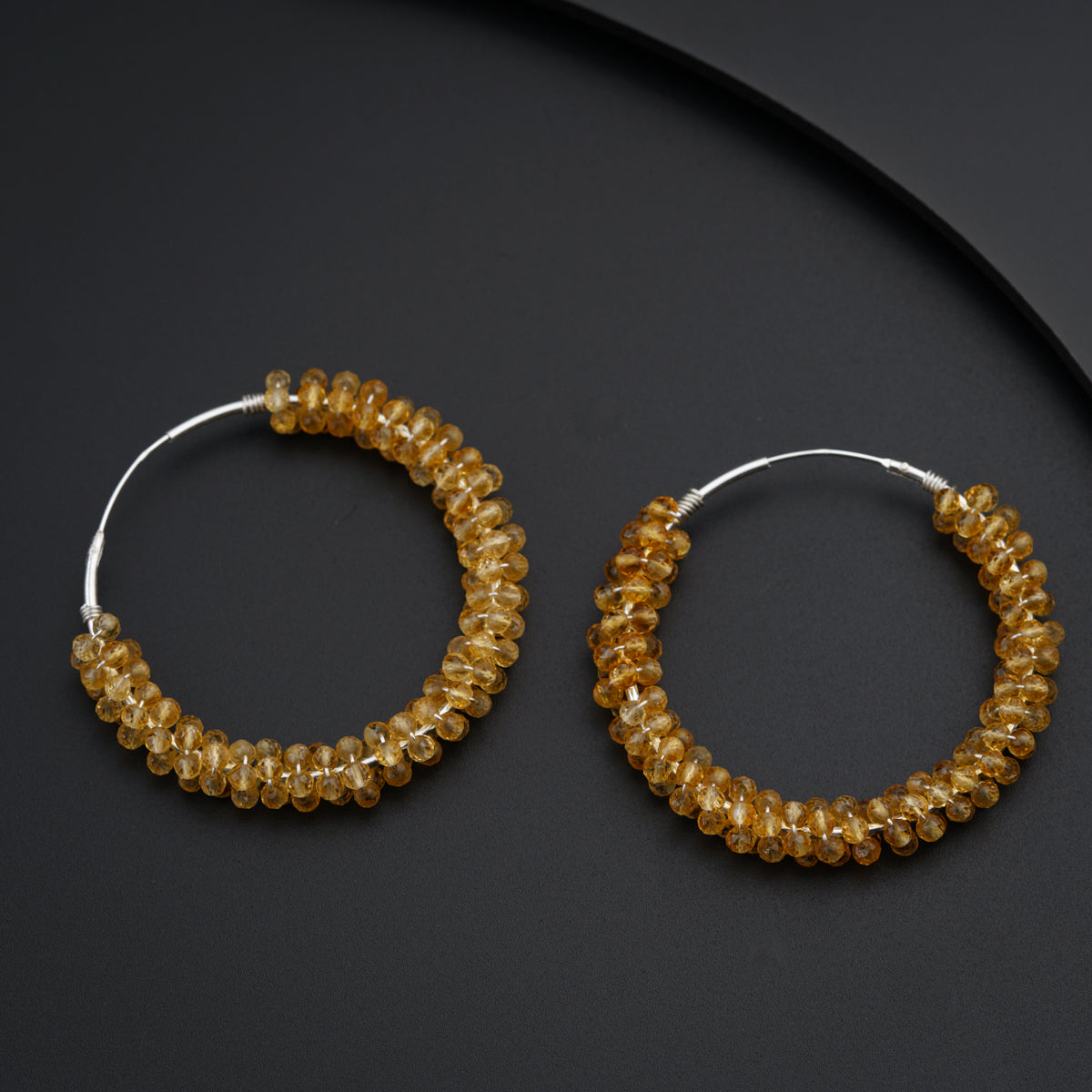 a pair of hoop earrings made of glass beads