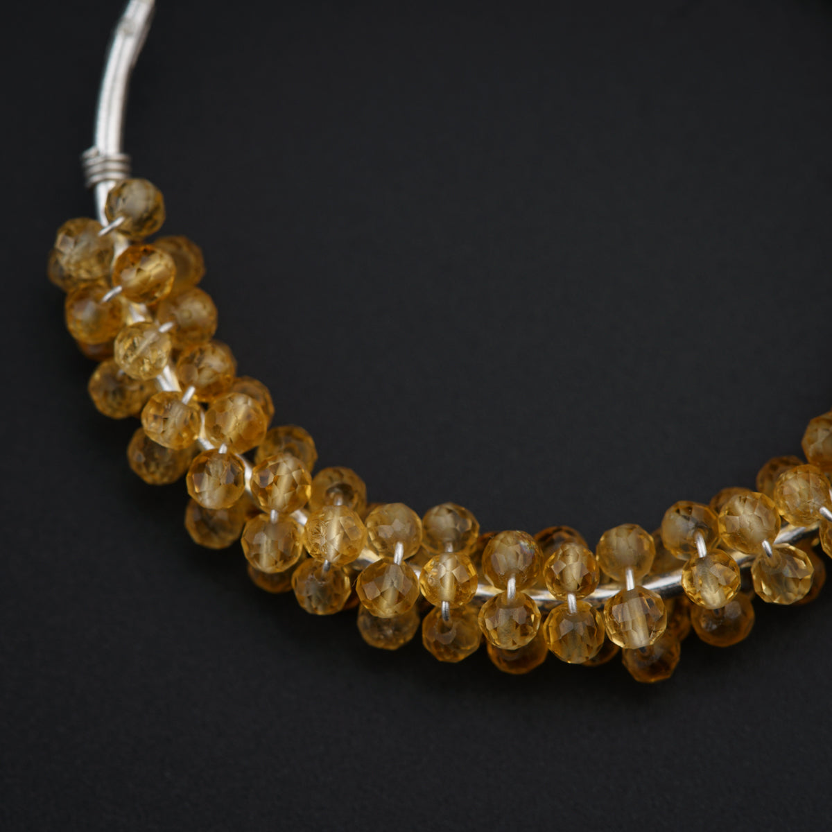a close up of a necklace on a black surface