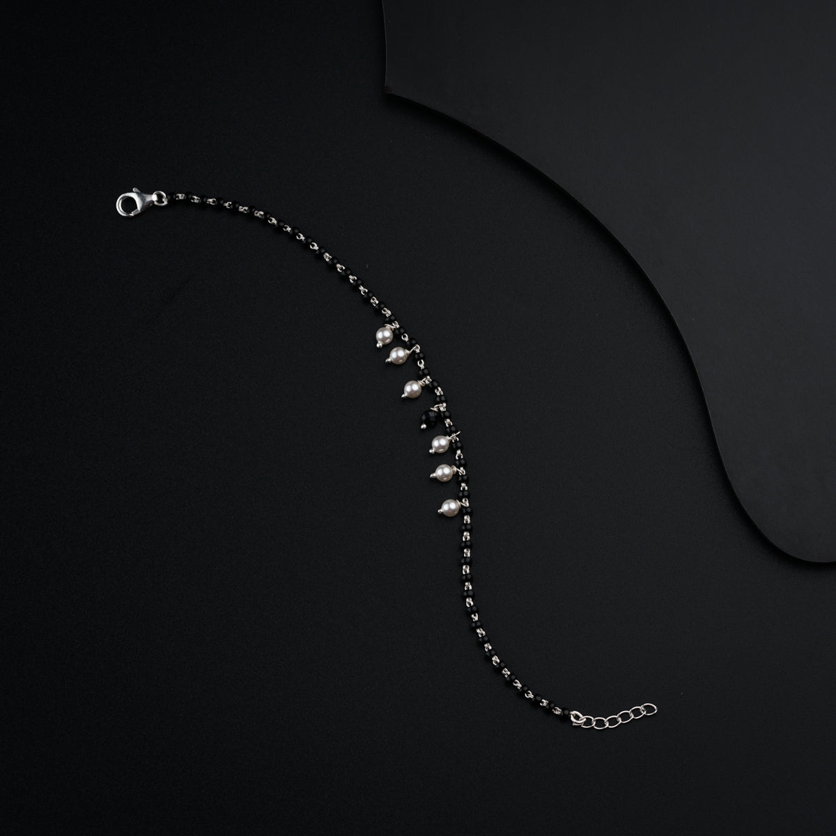 a black background with a silver chain and a black background
