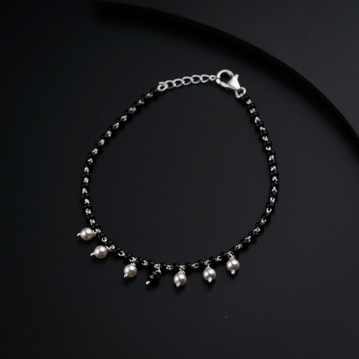 a black beaded bracelet with silver beads