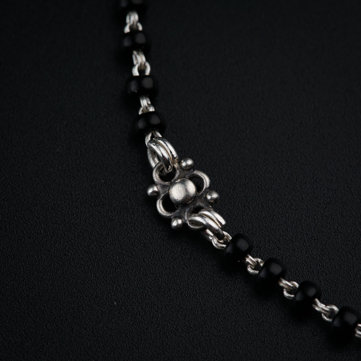 a black beaded necklace with a skull on it
