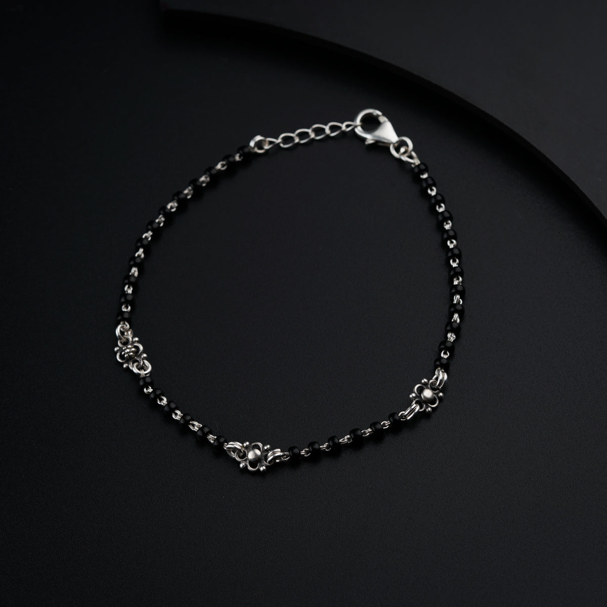 a black beaded bracelet on a black surface