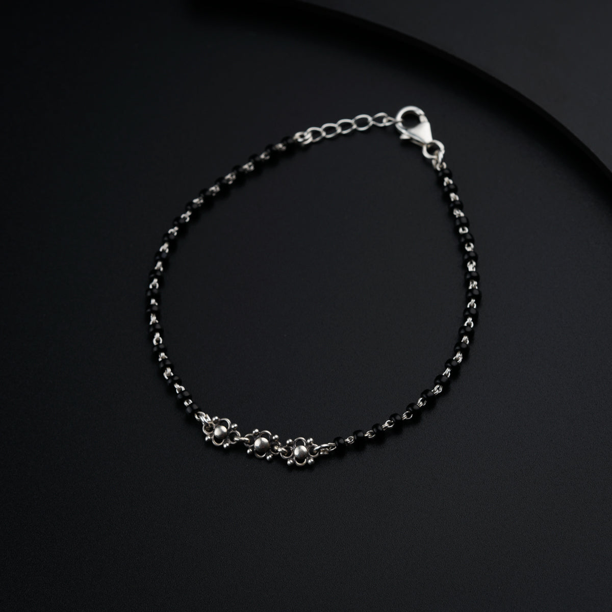 a black and silver bracelet on a black surface