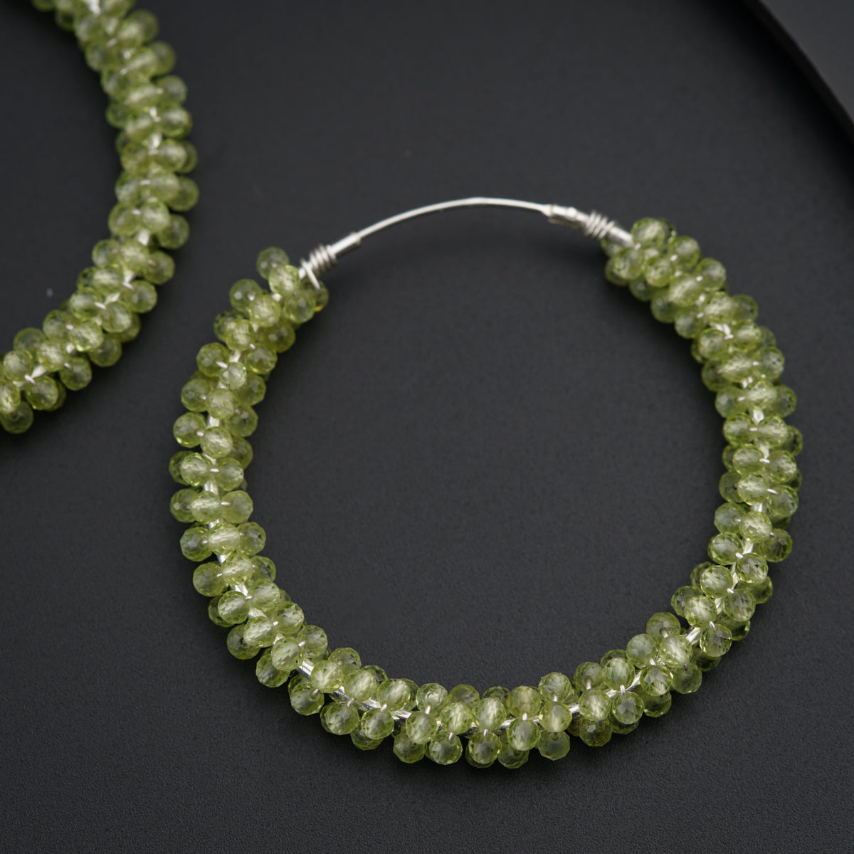 a pair of green beaded hoop earrings