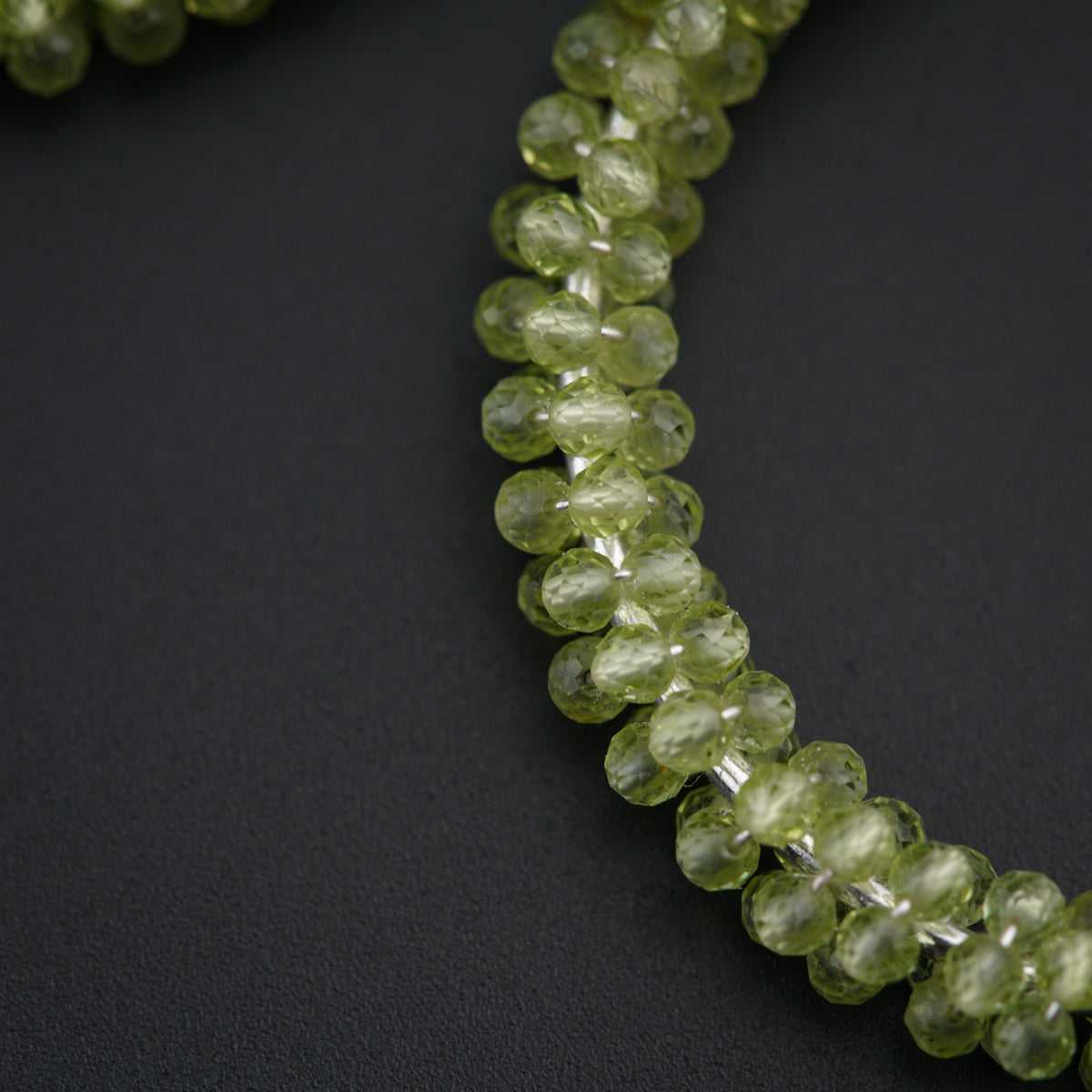 a close up of a necklace made of green beads