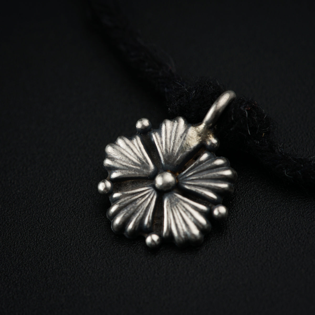 a close up of a silver flower on a black background