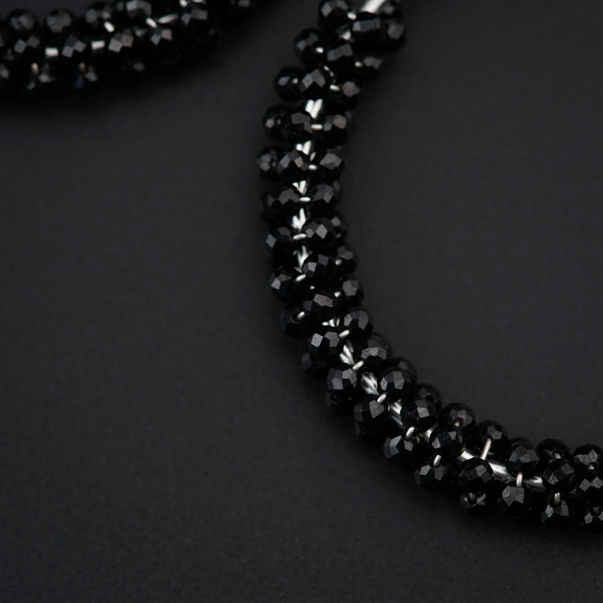 a close up of a necklace on a black surface