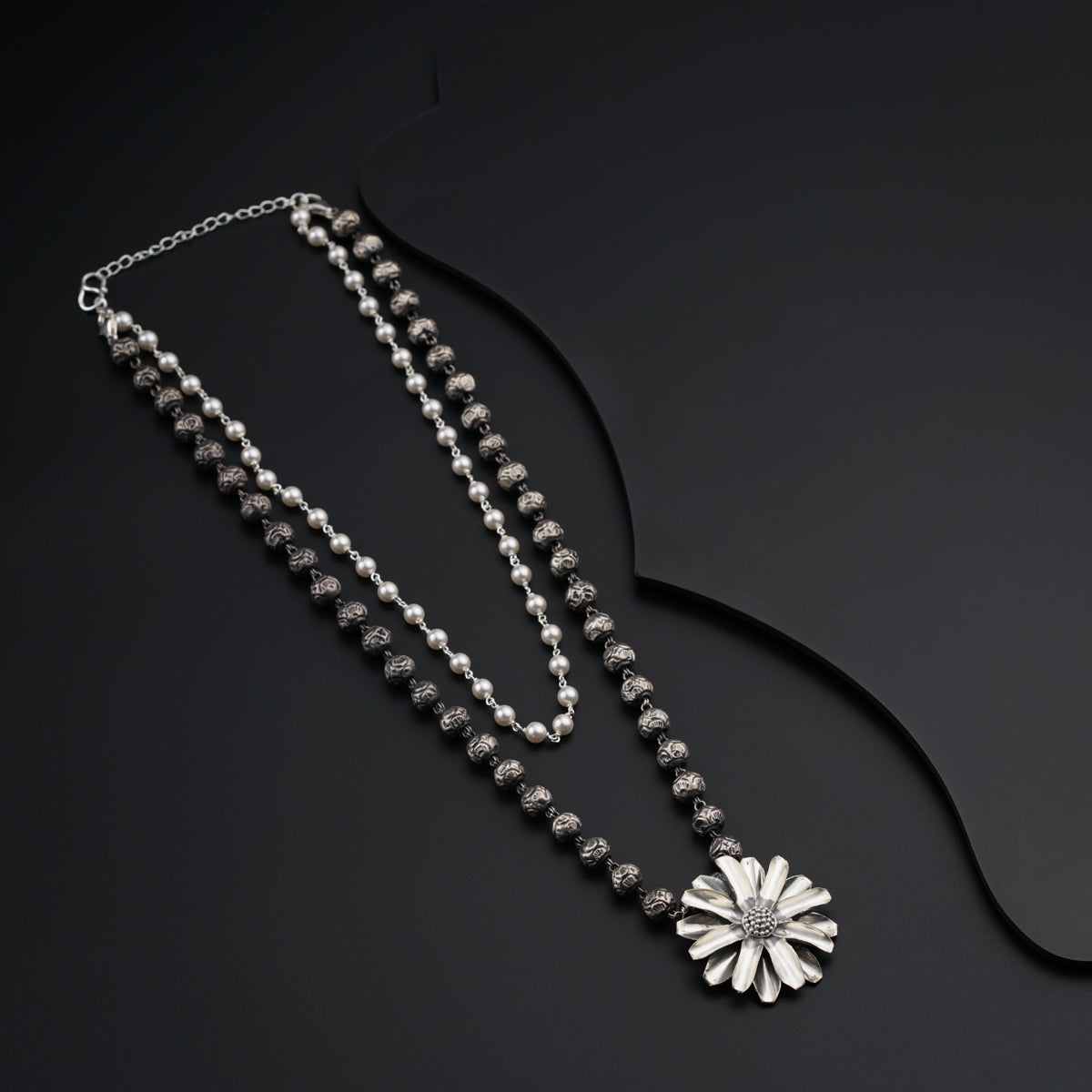 a long necklace with a flower on it
