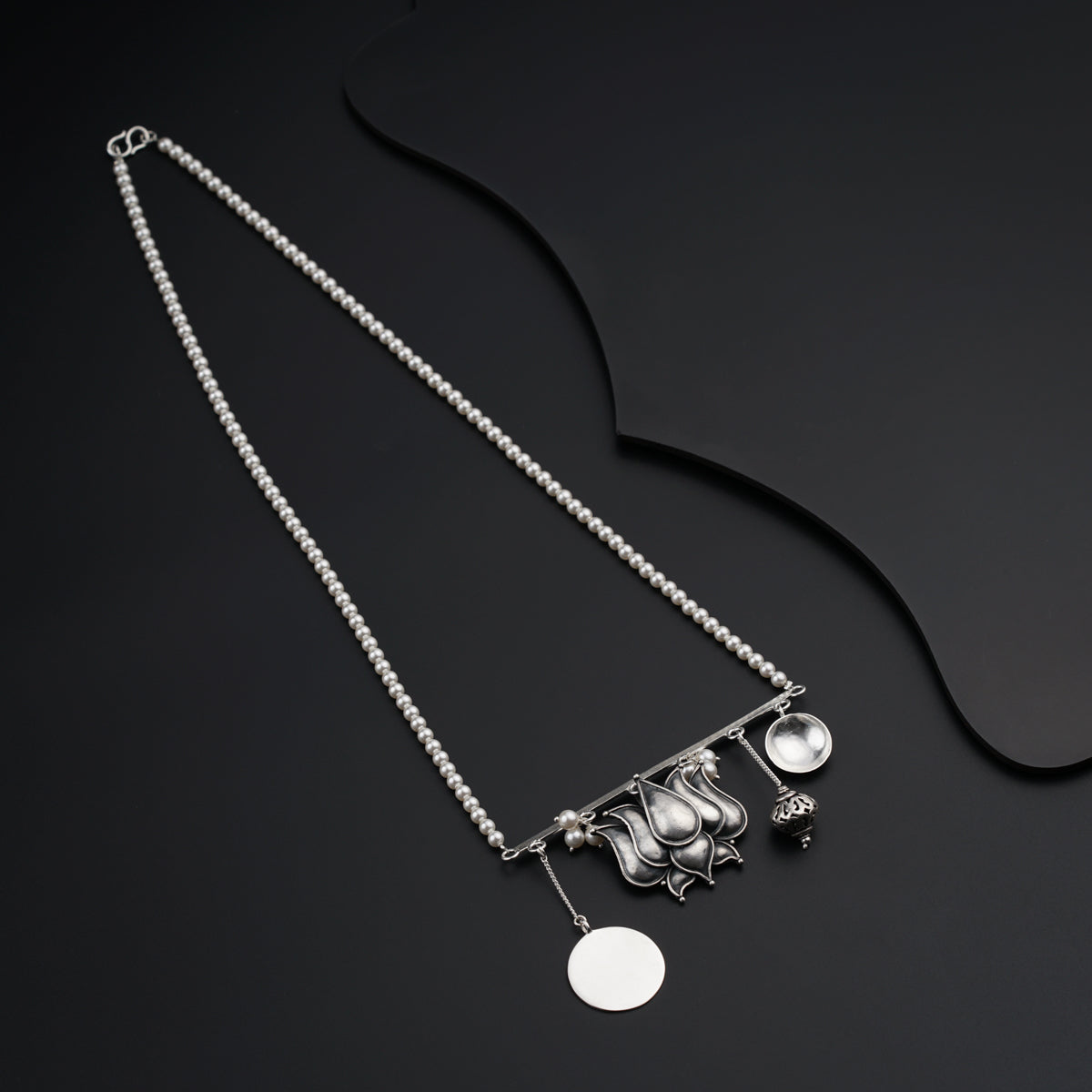 a silver necklace with a cat and a ball on it