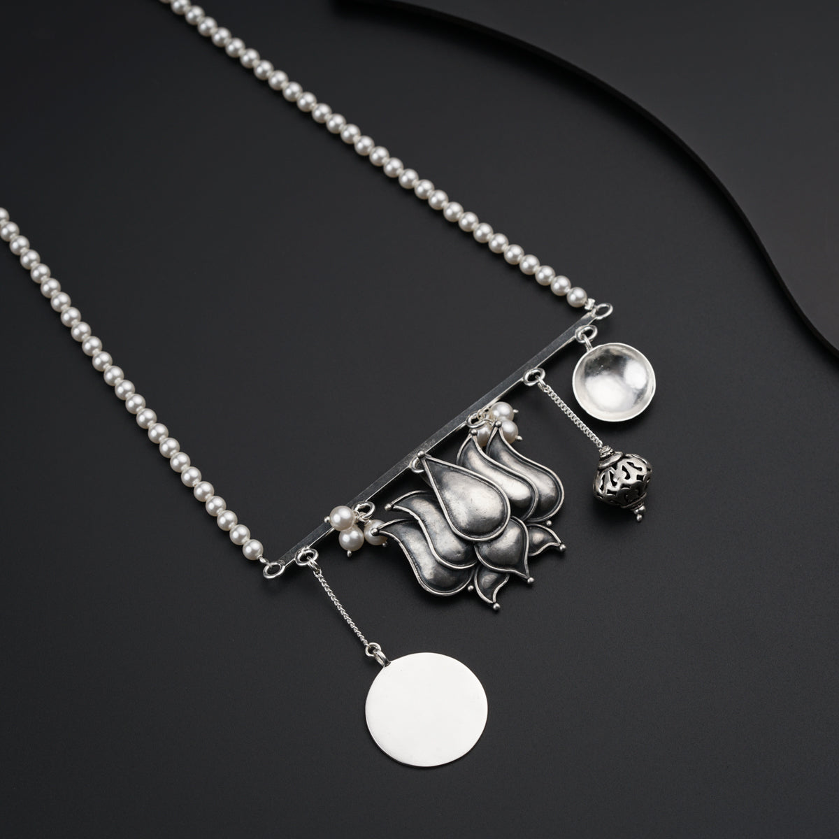 a necklace that has a silver object on it