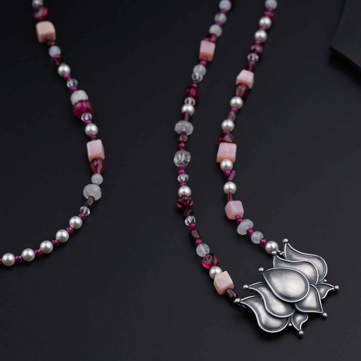 a long necklace with a flower design on it