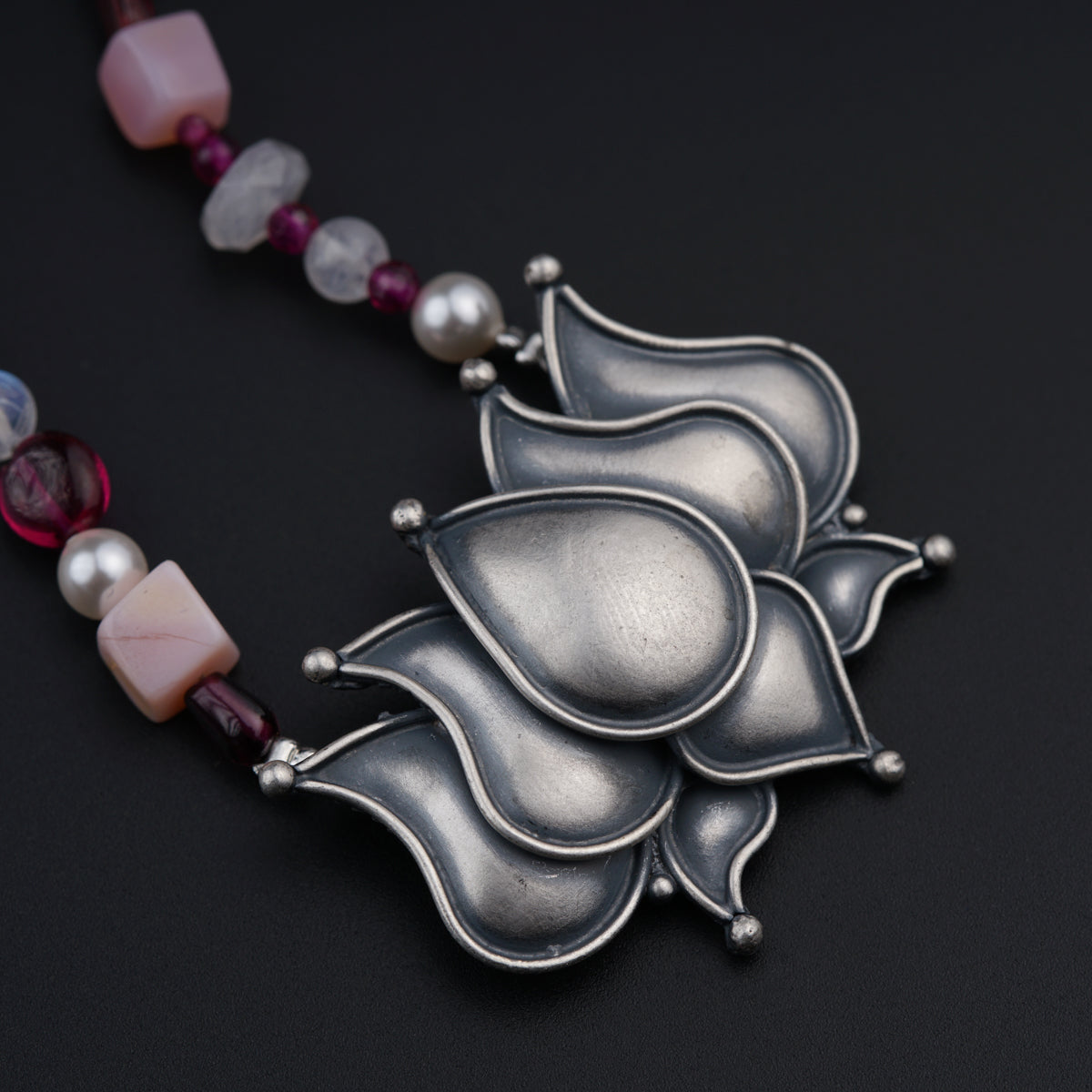 a necklace with beads and a flower design