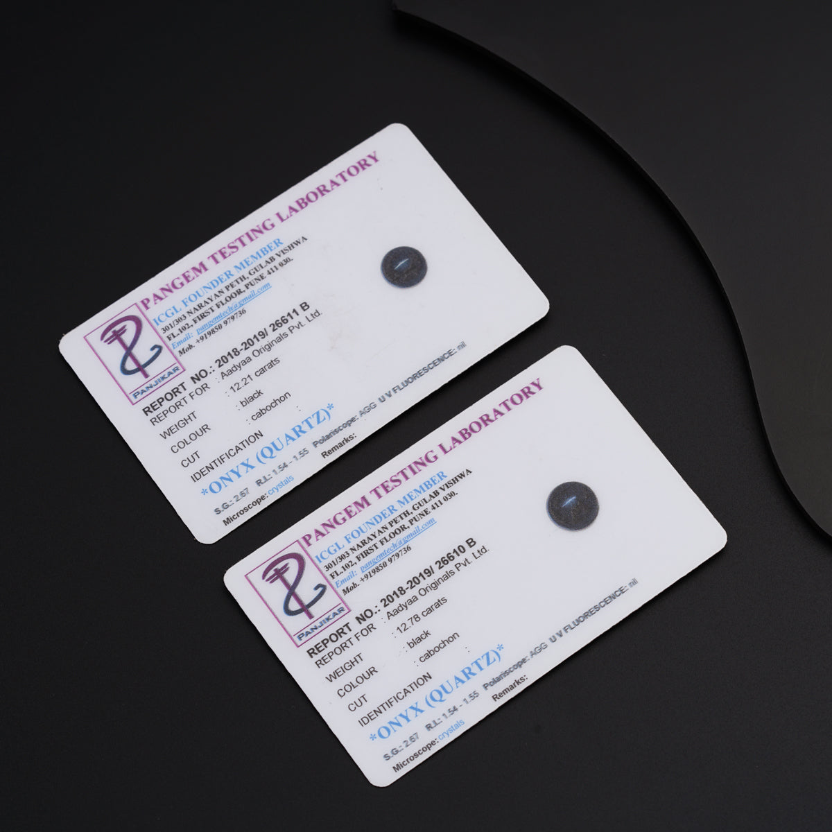 two business cards sitting next to a computer mouse