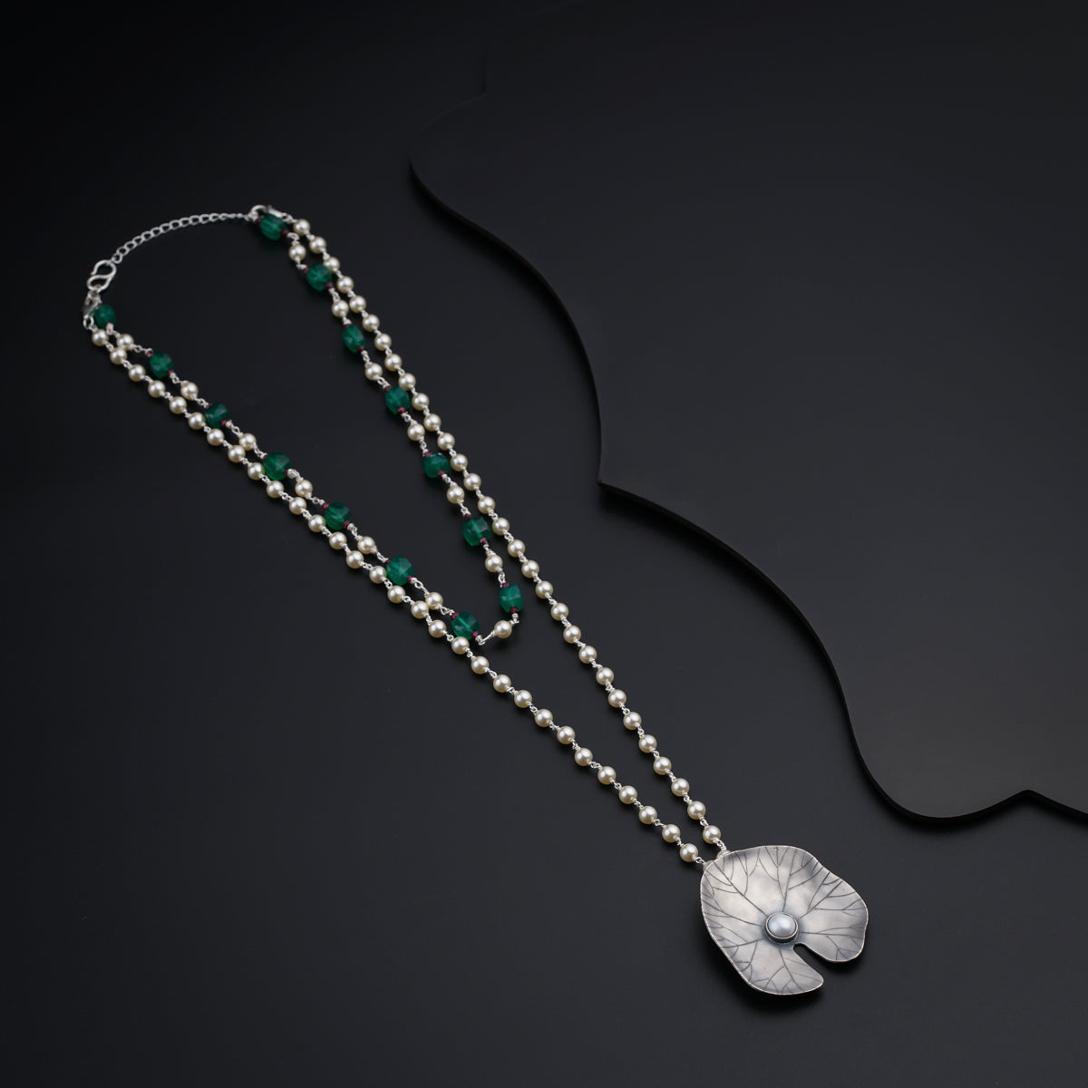 a long necklace with a flower on it