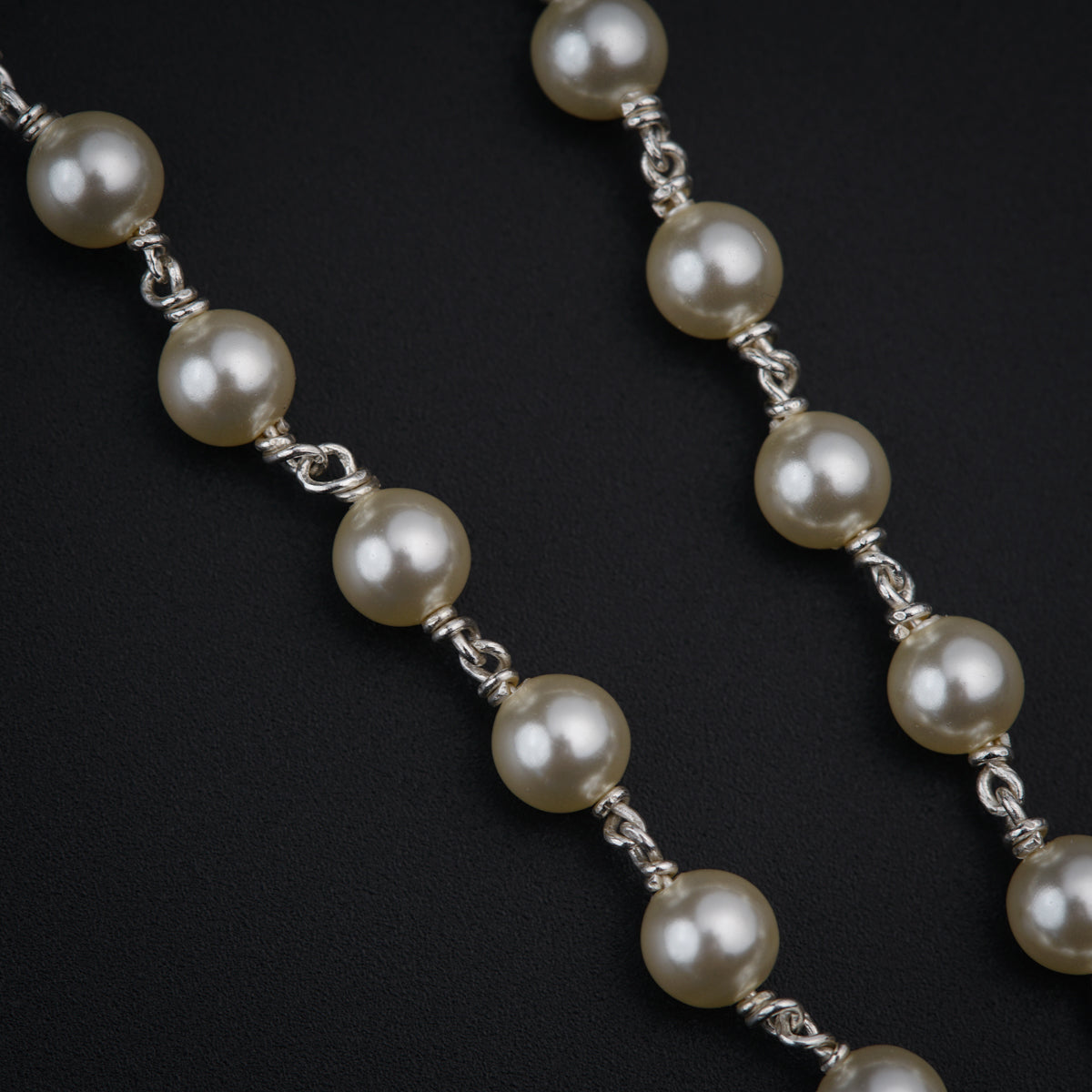 a close up of a necklace with pearls