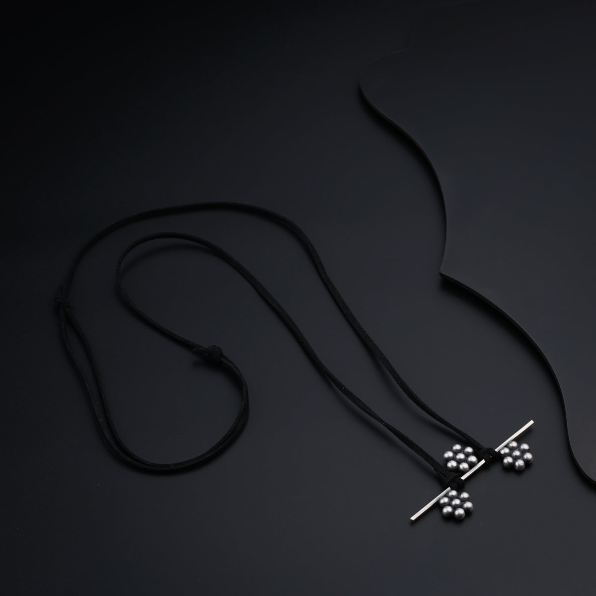 a necklace with a cross on a black background