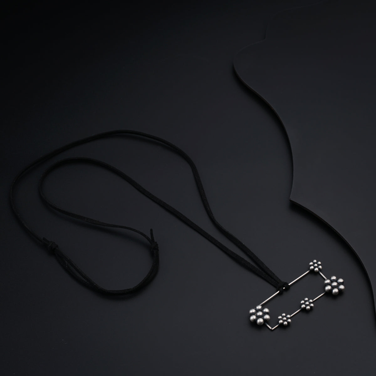 a necklace with four balls hanging from it