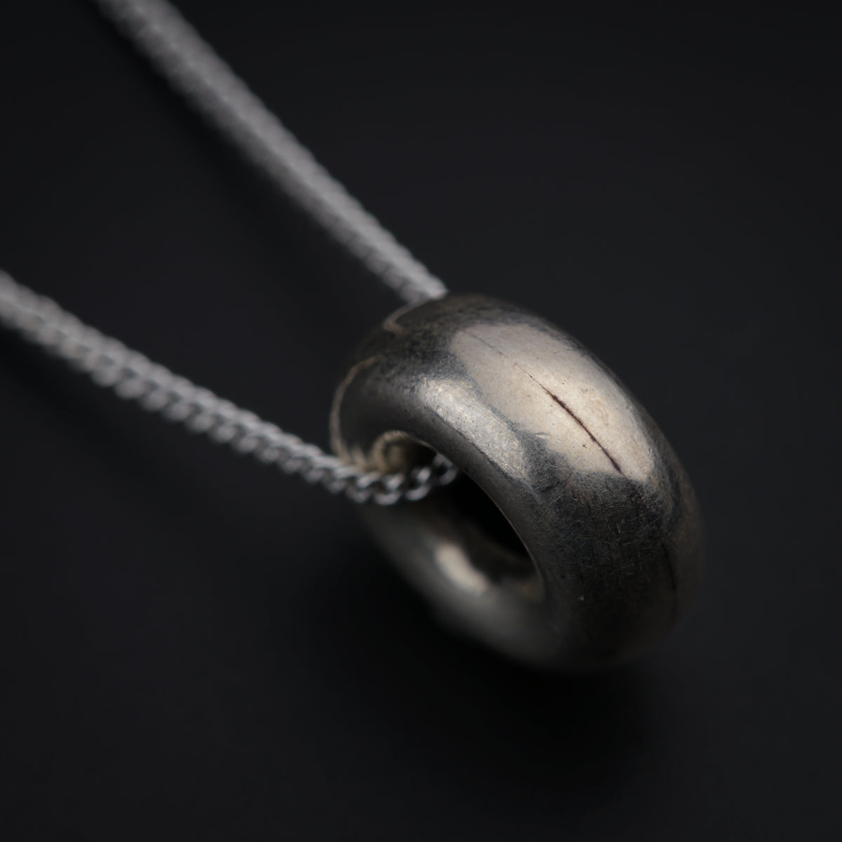 a close up of a metal object on a chain