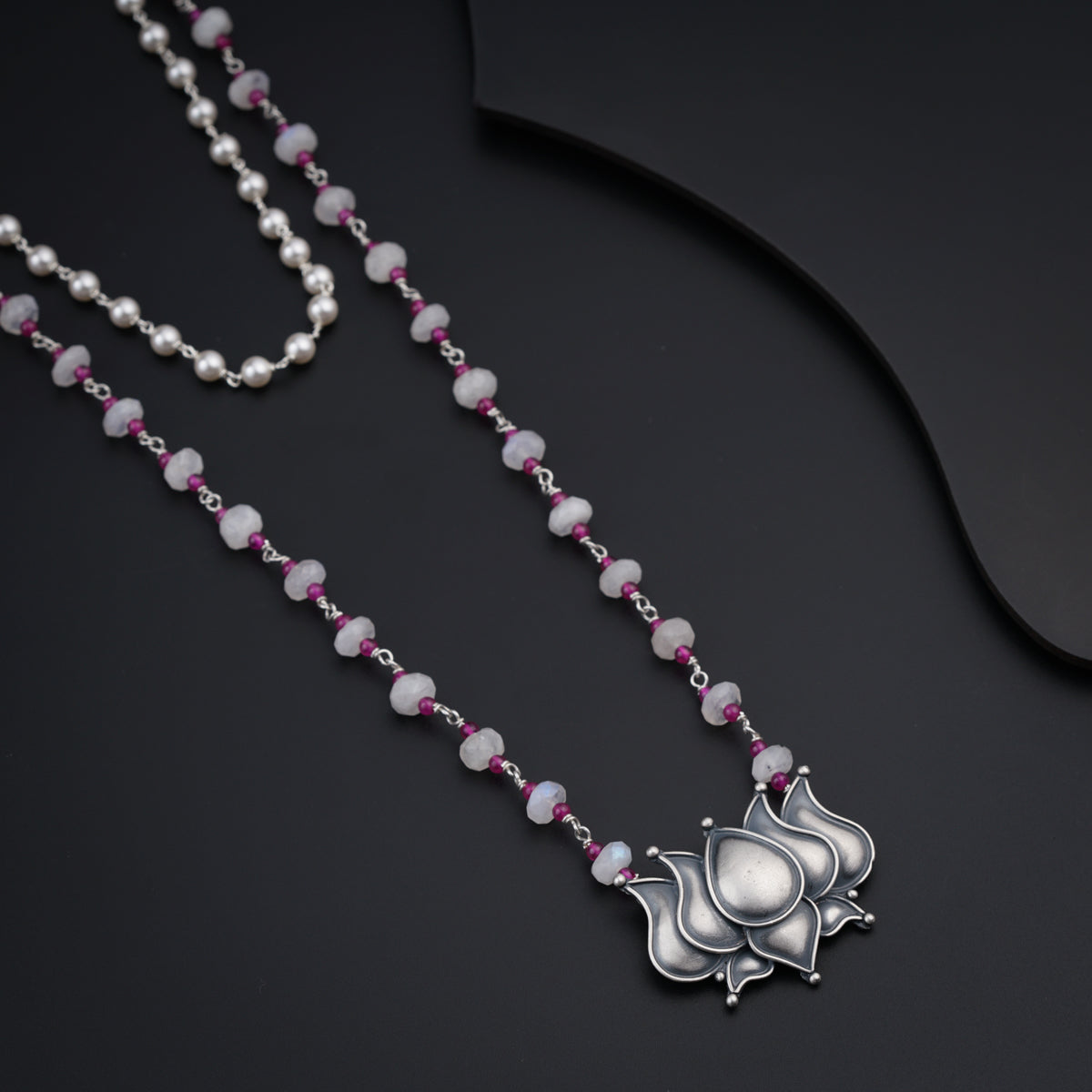 a long necklace with a flower design on it