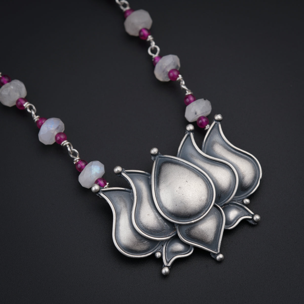 a necklace with a flower and beads on it