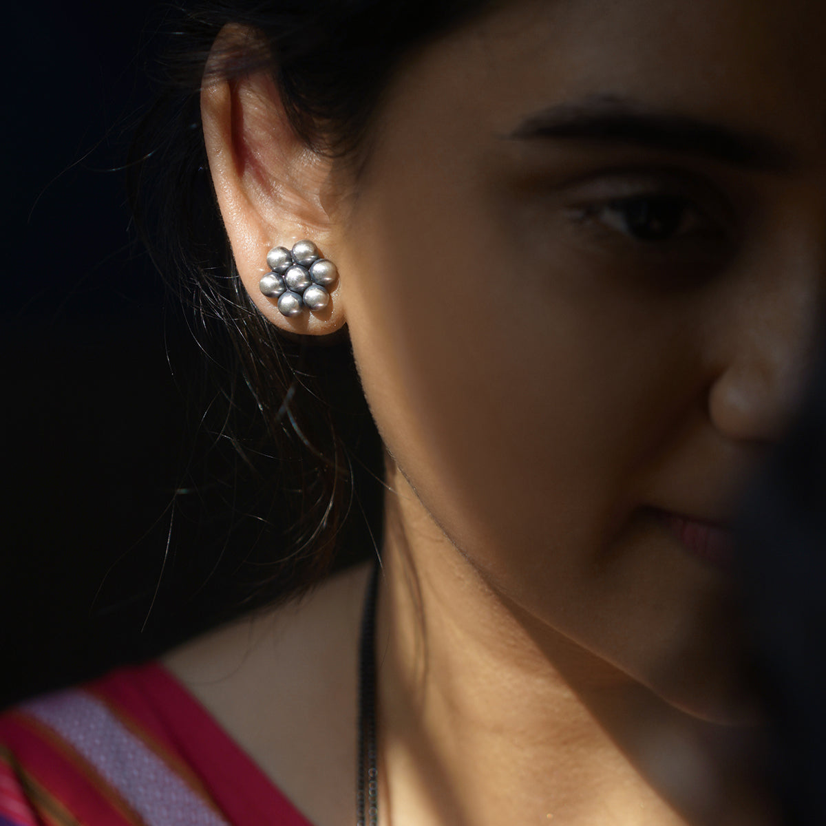 a close up of a person wearing a pair of earrings