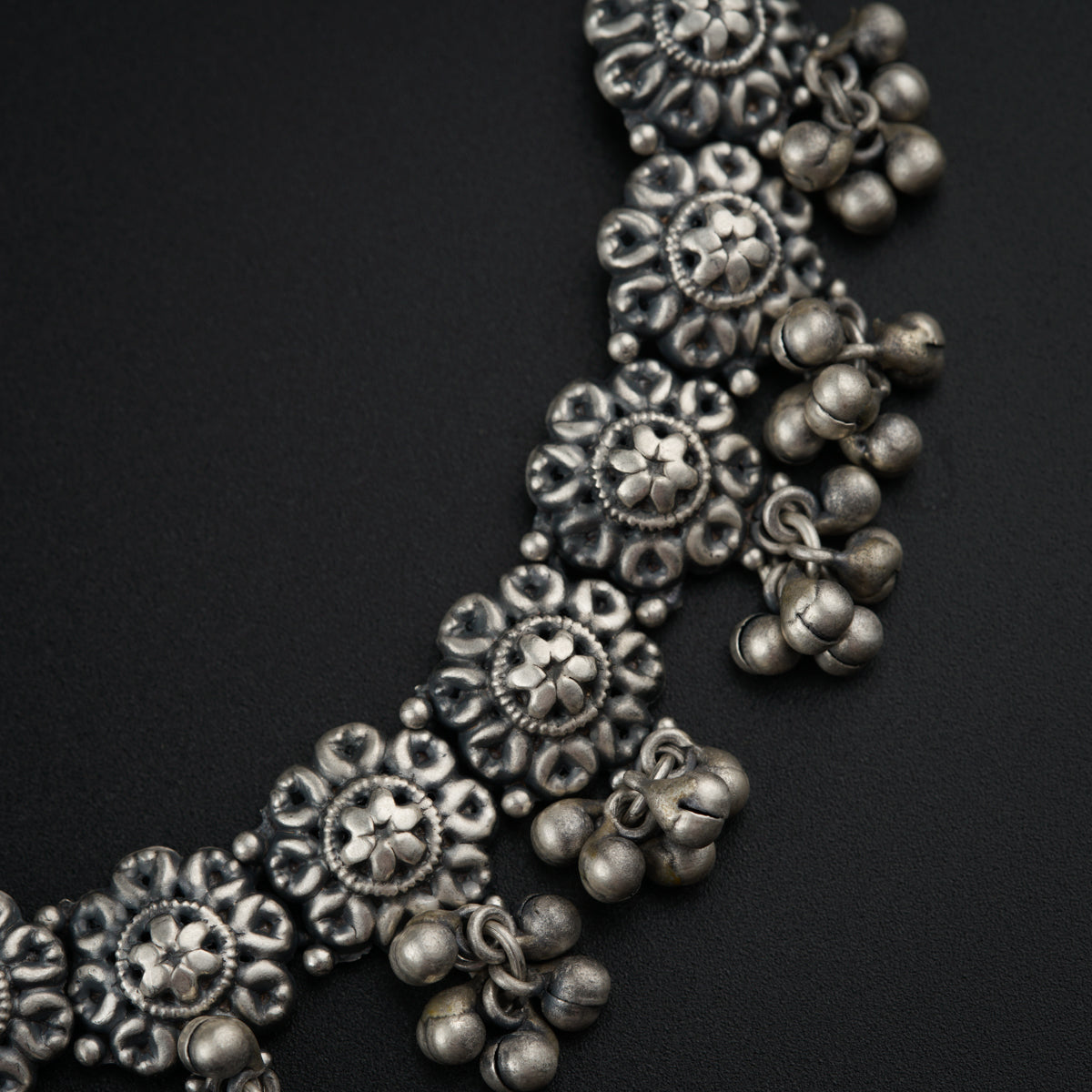 a close up of a necklace on a black surface