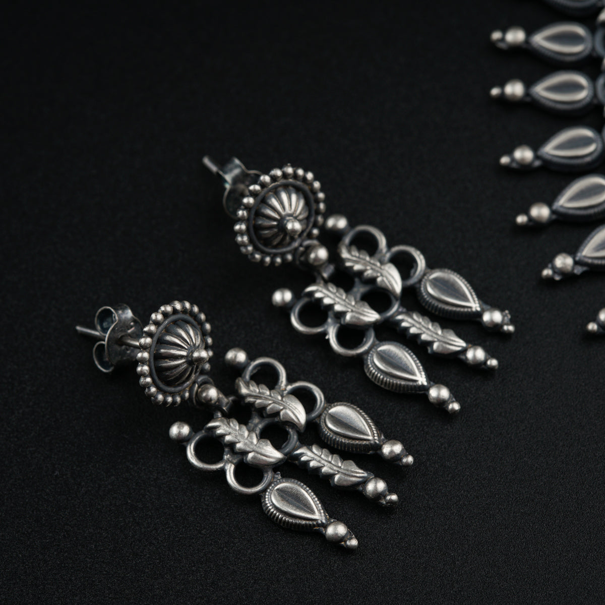 a close up of a pair of earrings on a black surface