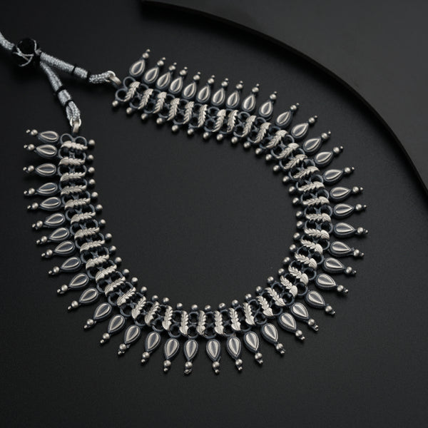 a black and silver necklace on a black surface