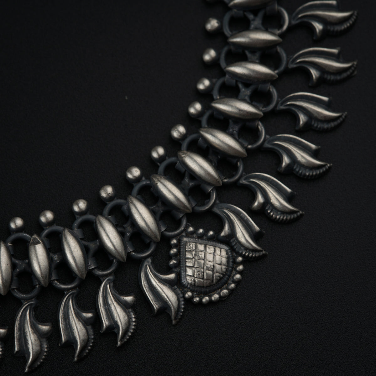 a close up of a necklace on a black surface