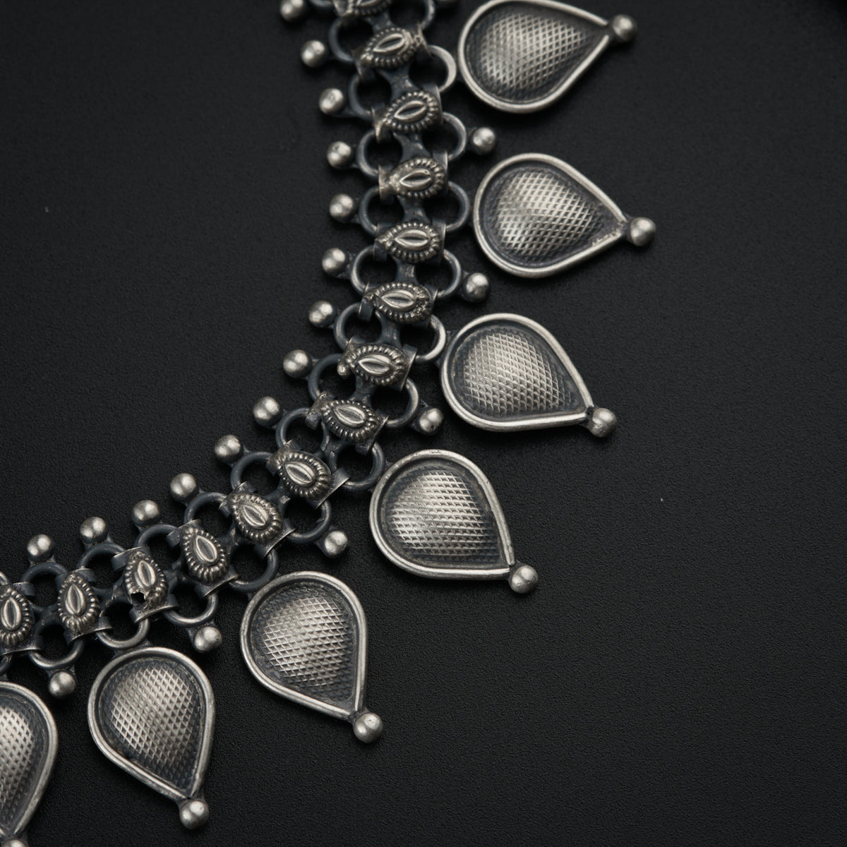a close up of a necklace on a black surface