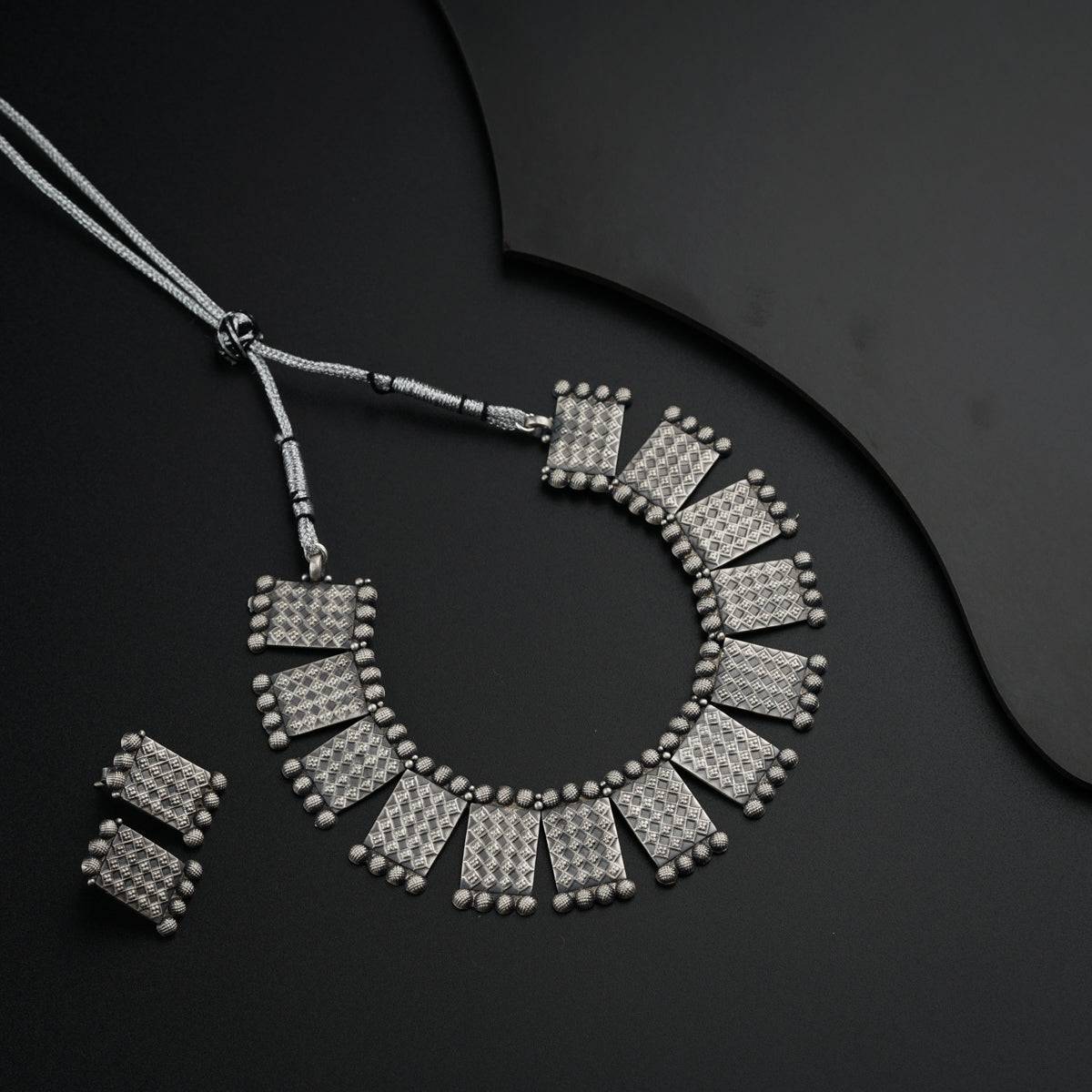 a necklace and earrings on a black surface