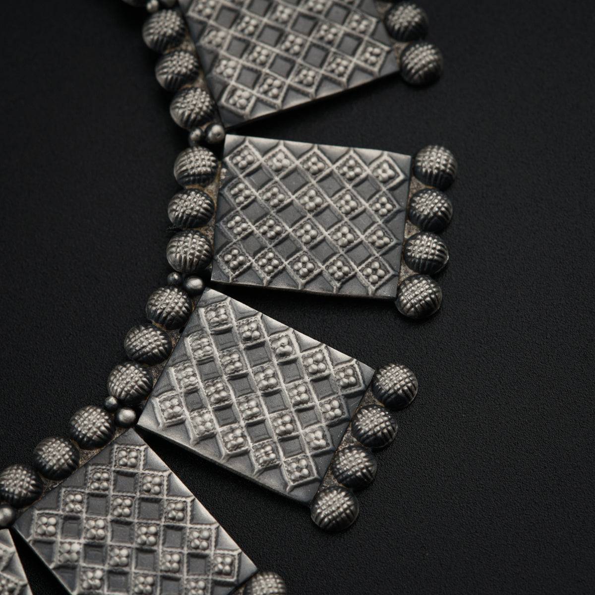 a close up of a necklace on a black surface