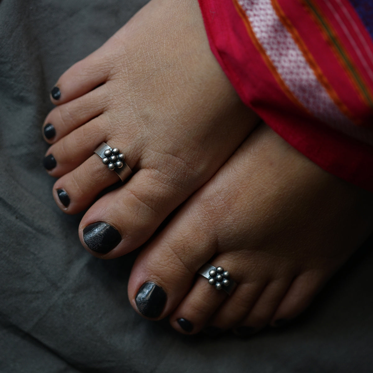 a woman's feet with silver and black toenails