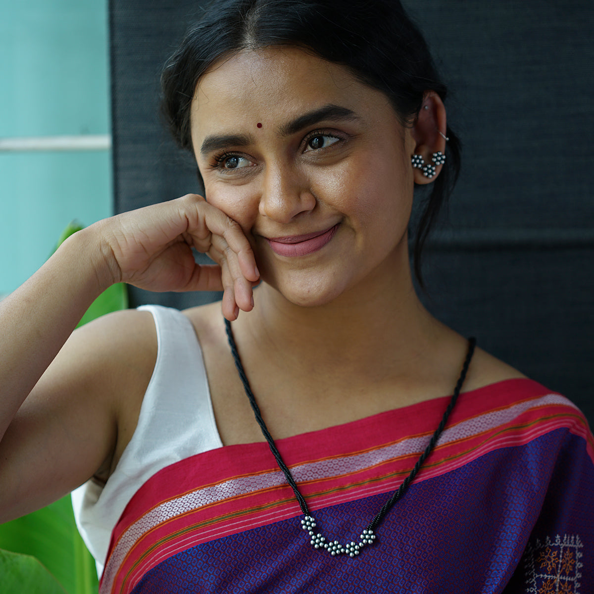 a woman wearing a necklace and a necklace with beads