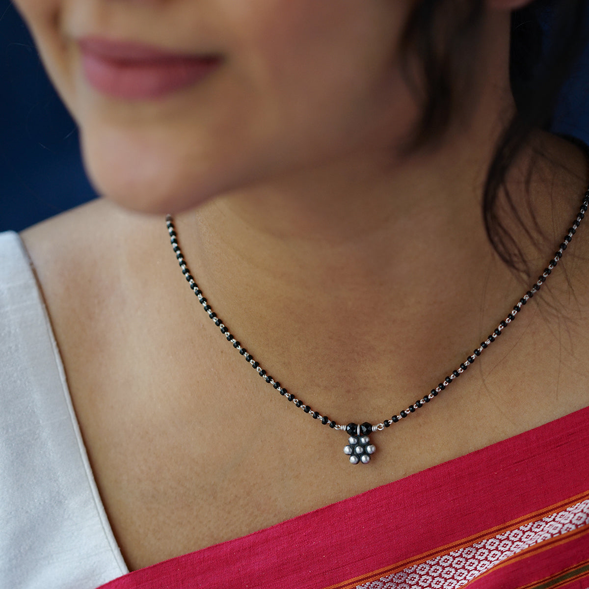 a close up of a woman wearing a necklace