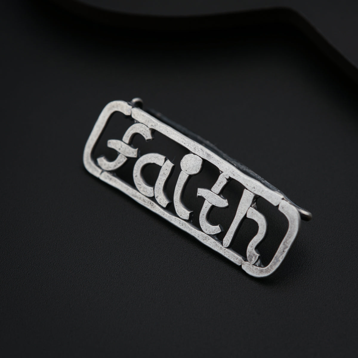 a metal tag with the word faith on it